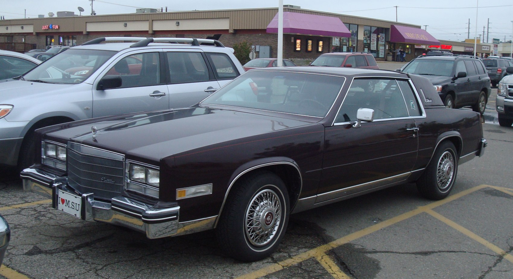 Vintage luxury coupe with wire spoke wheels and vinyl roof.