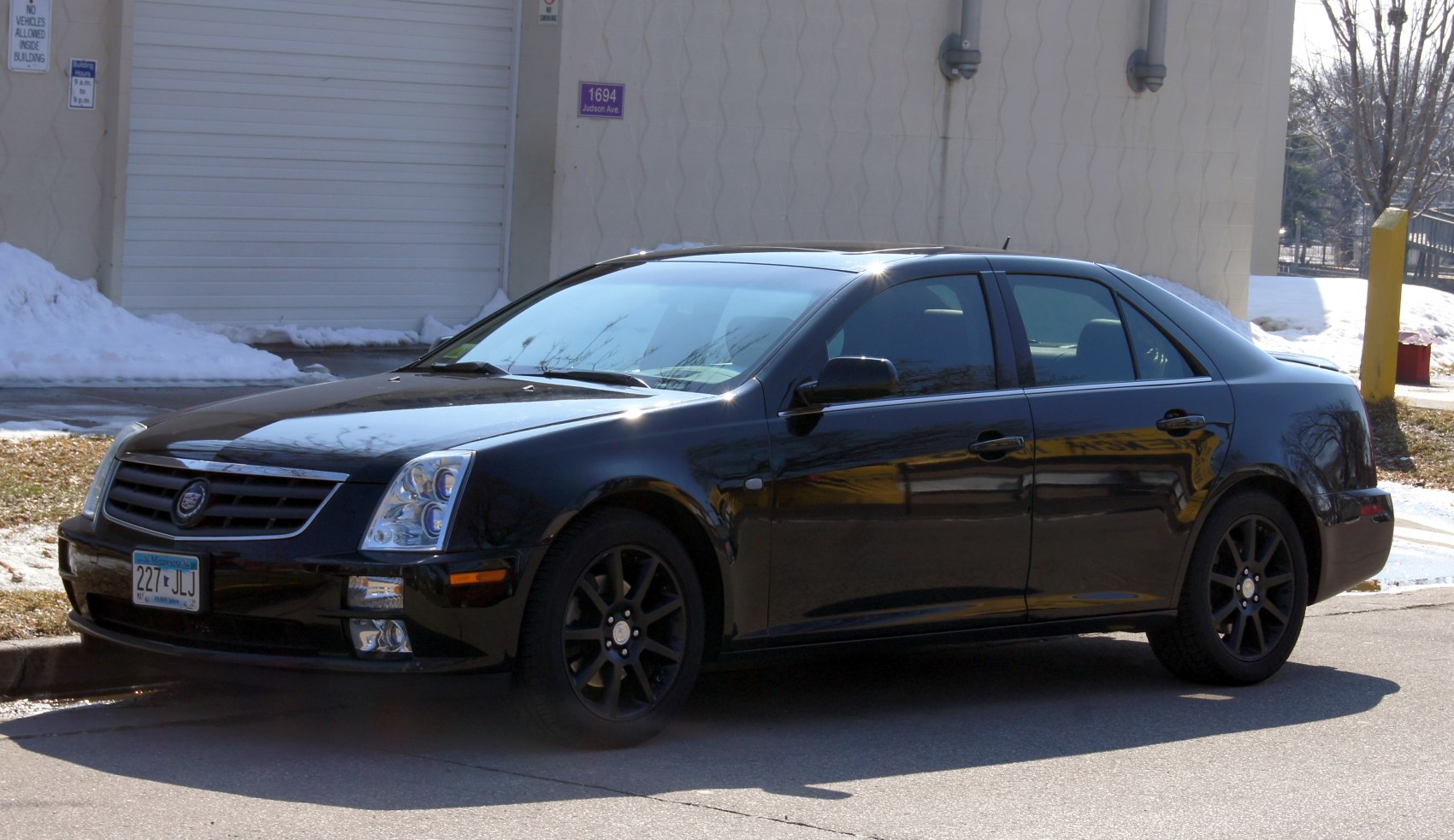 Black sedan with distinctive front grille, modern headlights, and alloy wheels.