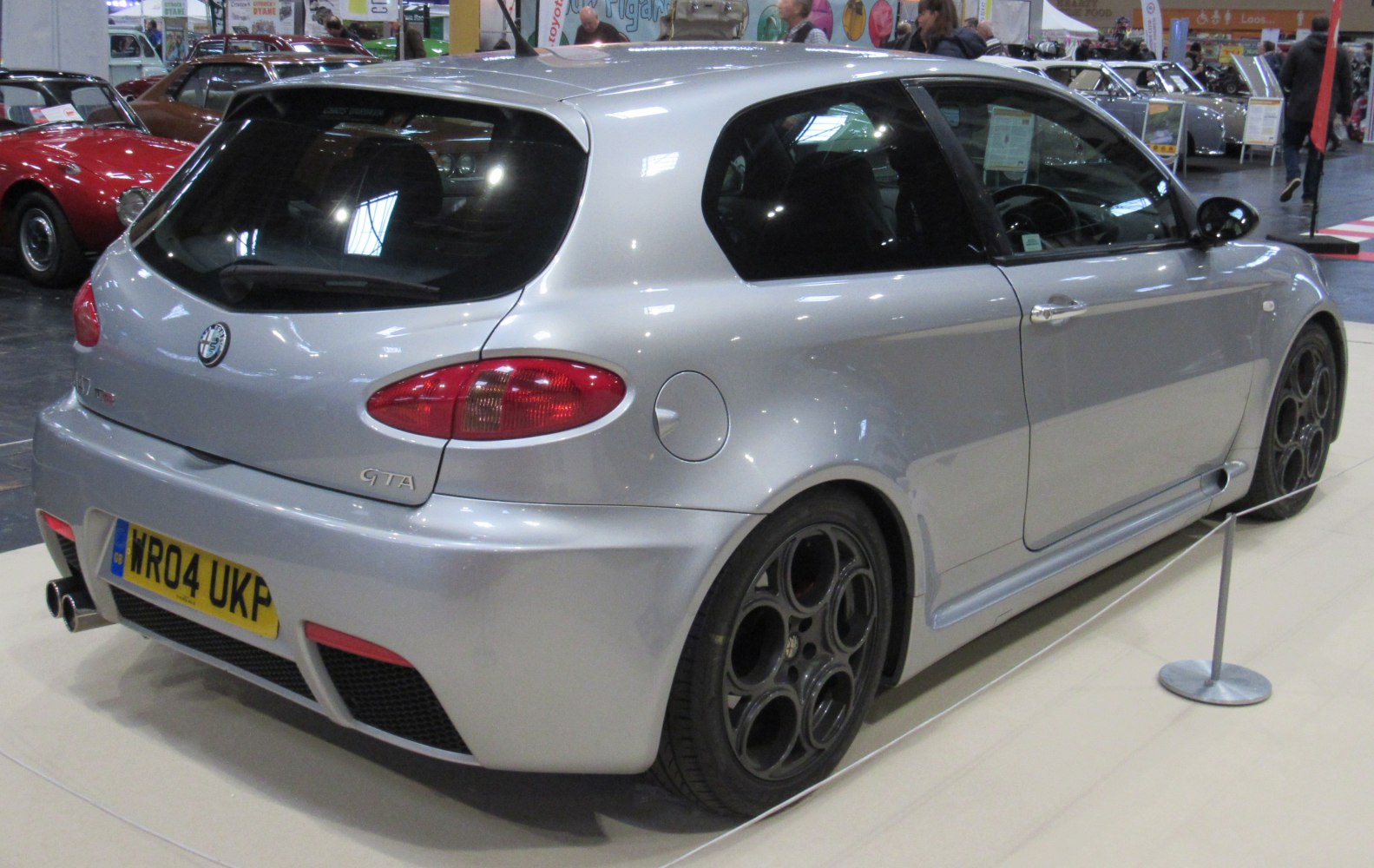 Silver sporty hatchback with round black alloy wheels and distinctive rear design