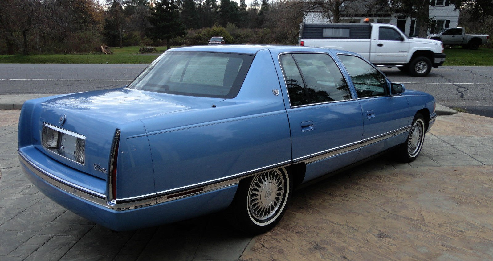 Rear view of blue sedan with vertical taillights and wire-spoke wheels