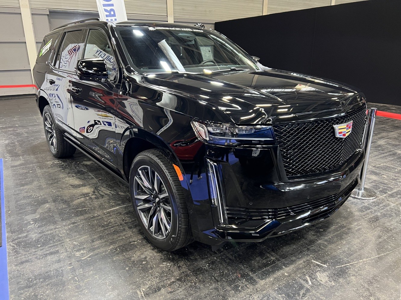 Front grille and alloy wheels of a sleek black luxury SUV.