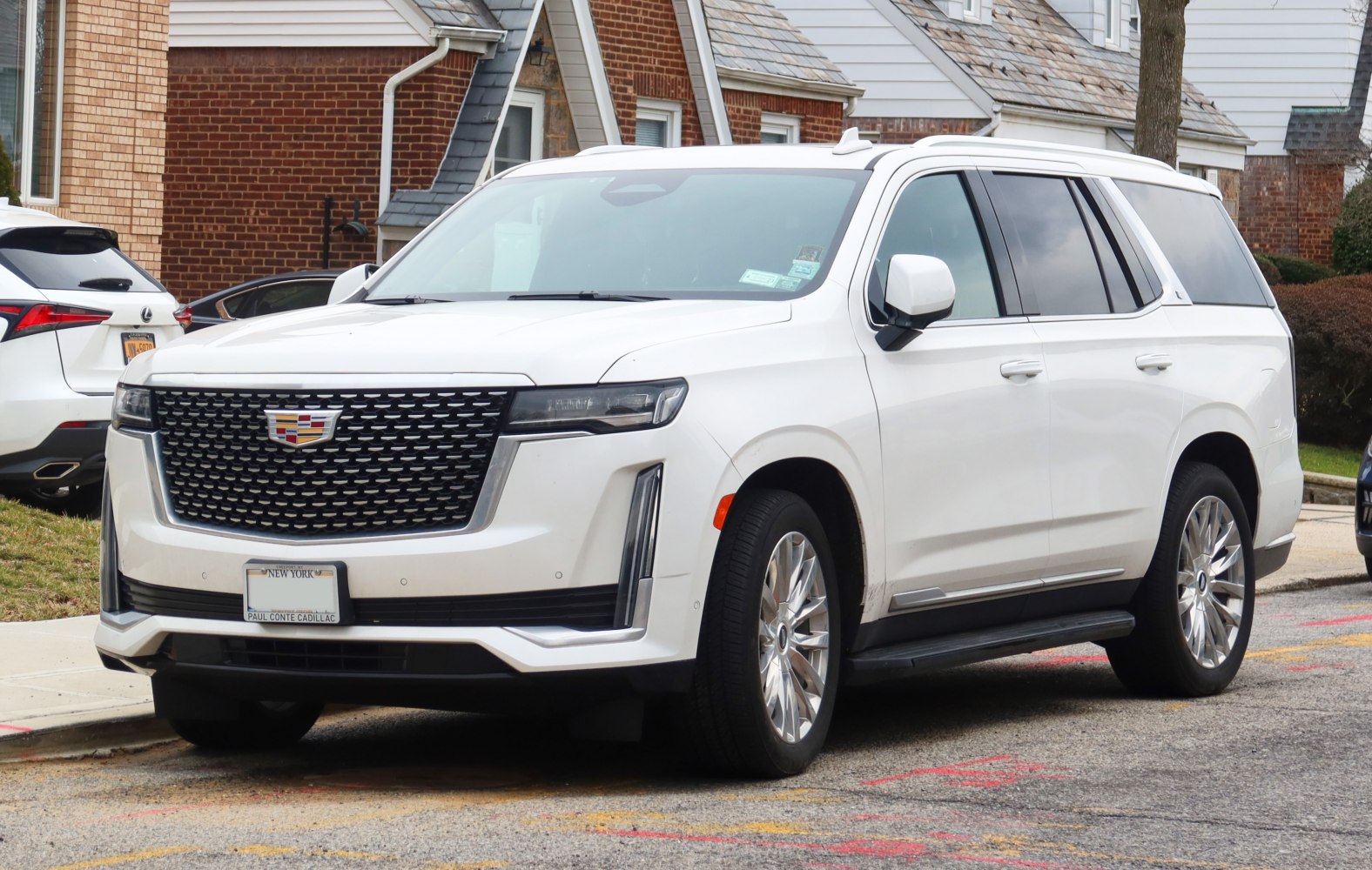 White luxury SUV with large black mesh grille and vertical LED lights