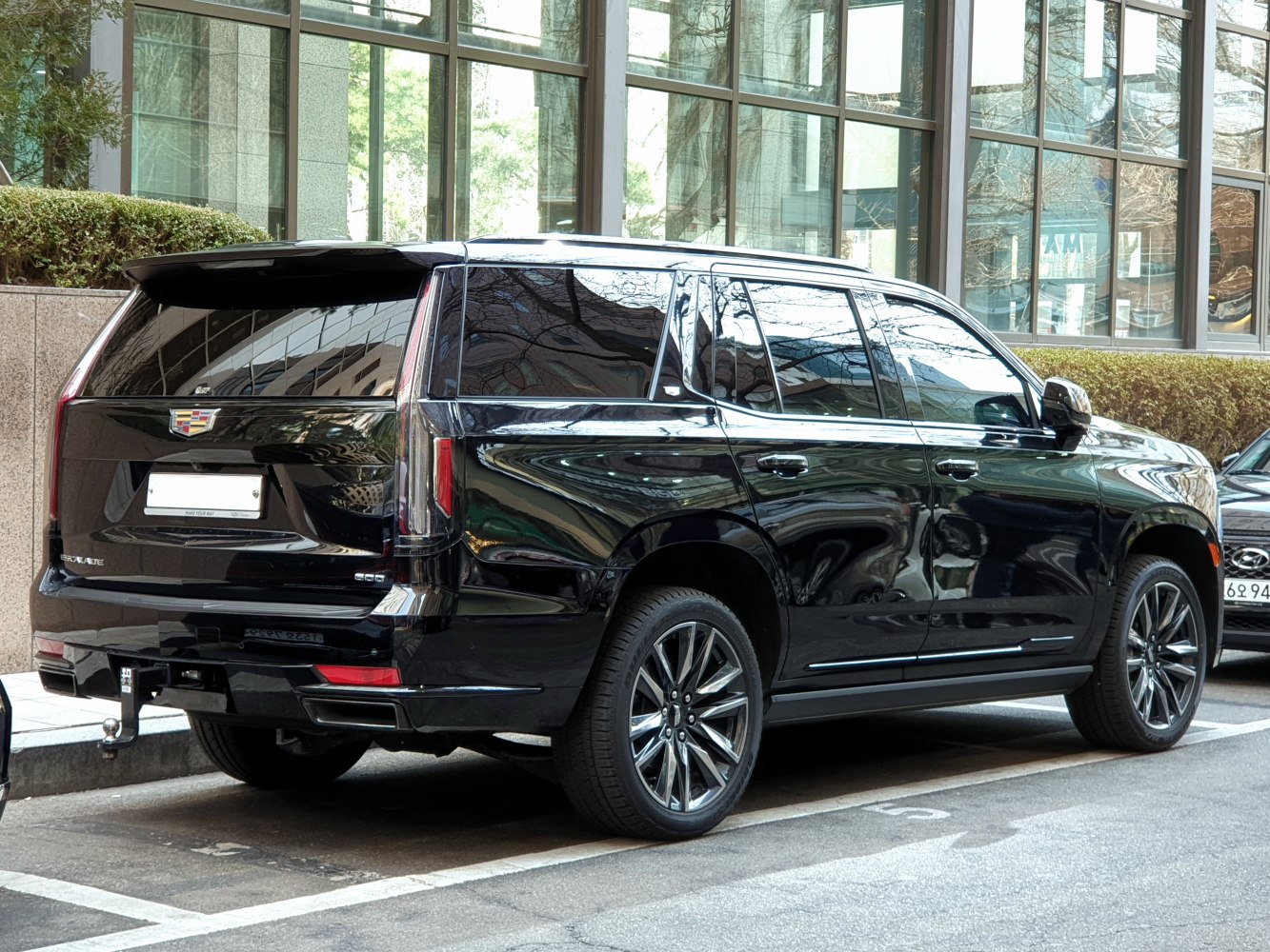 Rear and side profile of a large luxury SUV with vertical tail lights and sporty wheels