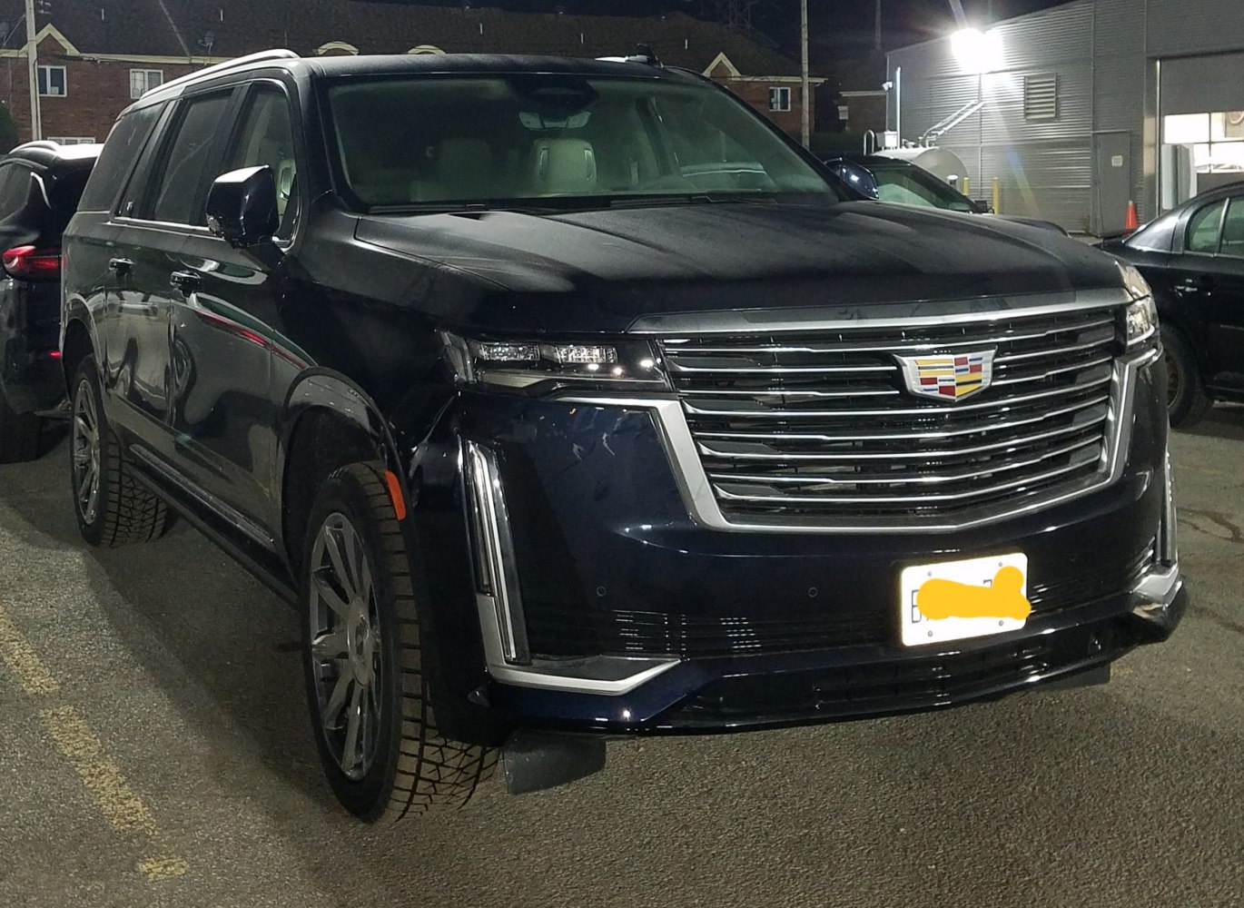 Large chrome grille and LED headlights of a luxury full-size SUV at night