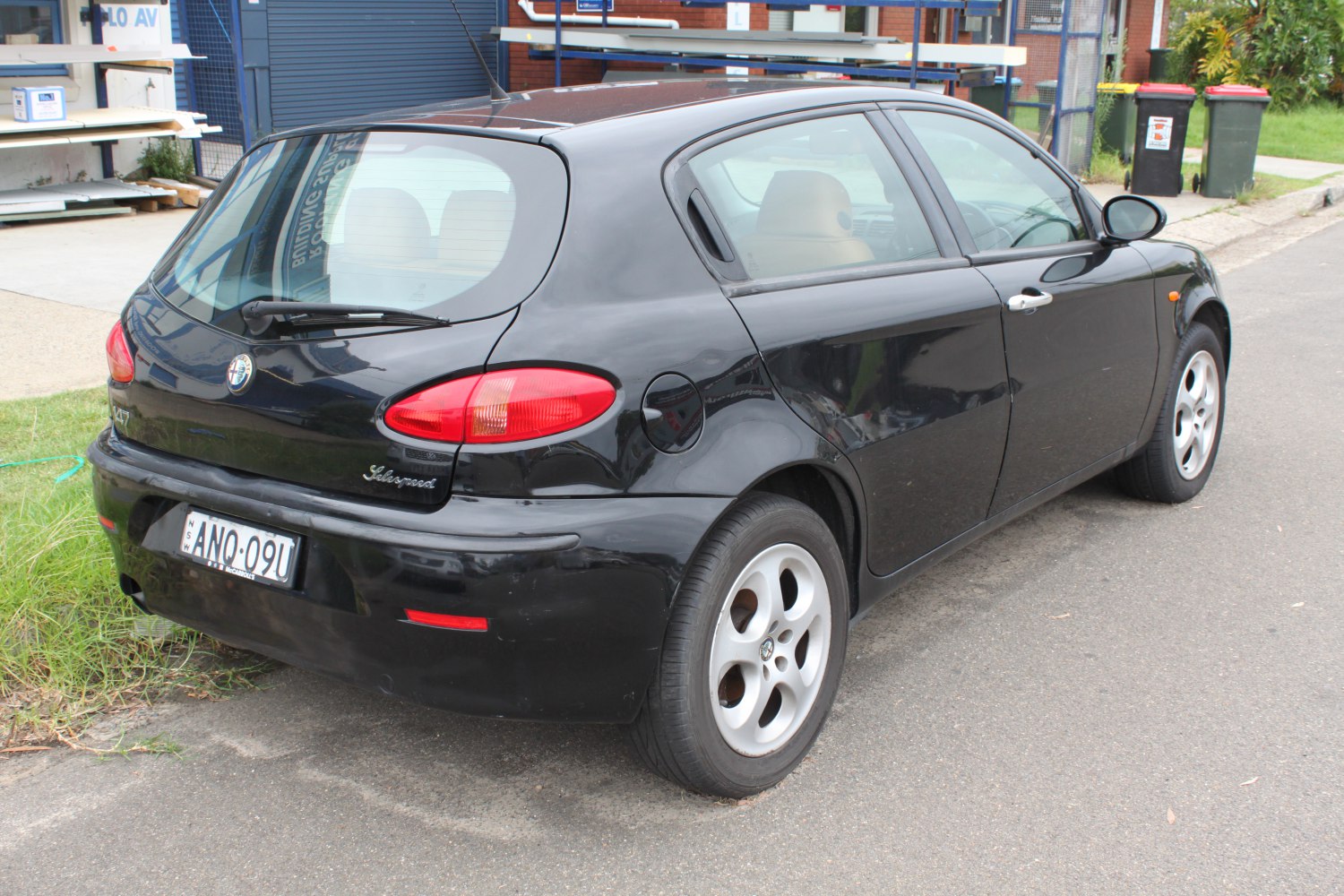 Rear side profile of a black 5-door hatchback with distinctive taillights and alloy wheels