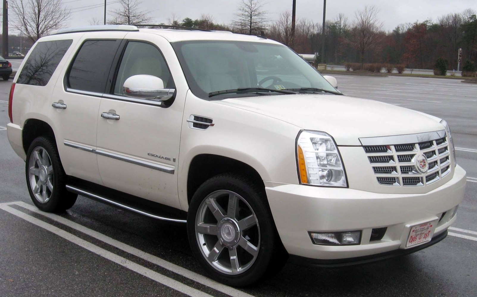 Front-side view of white luxury SUV with chrome grille and alloy wheels