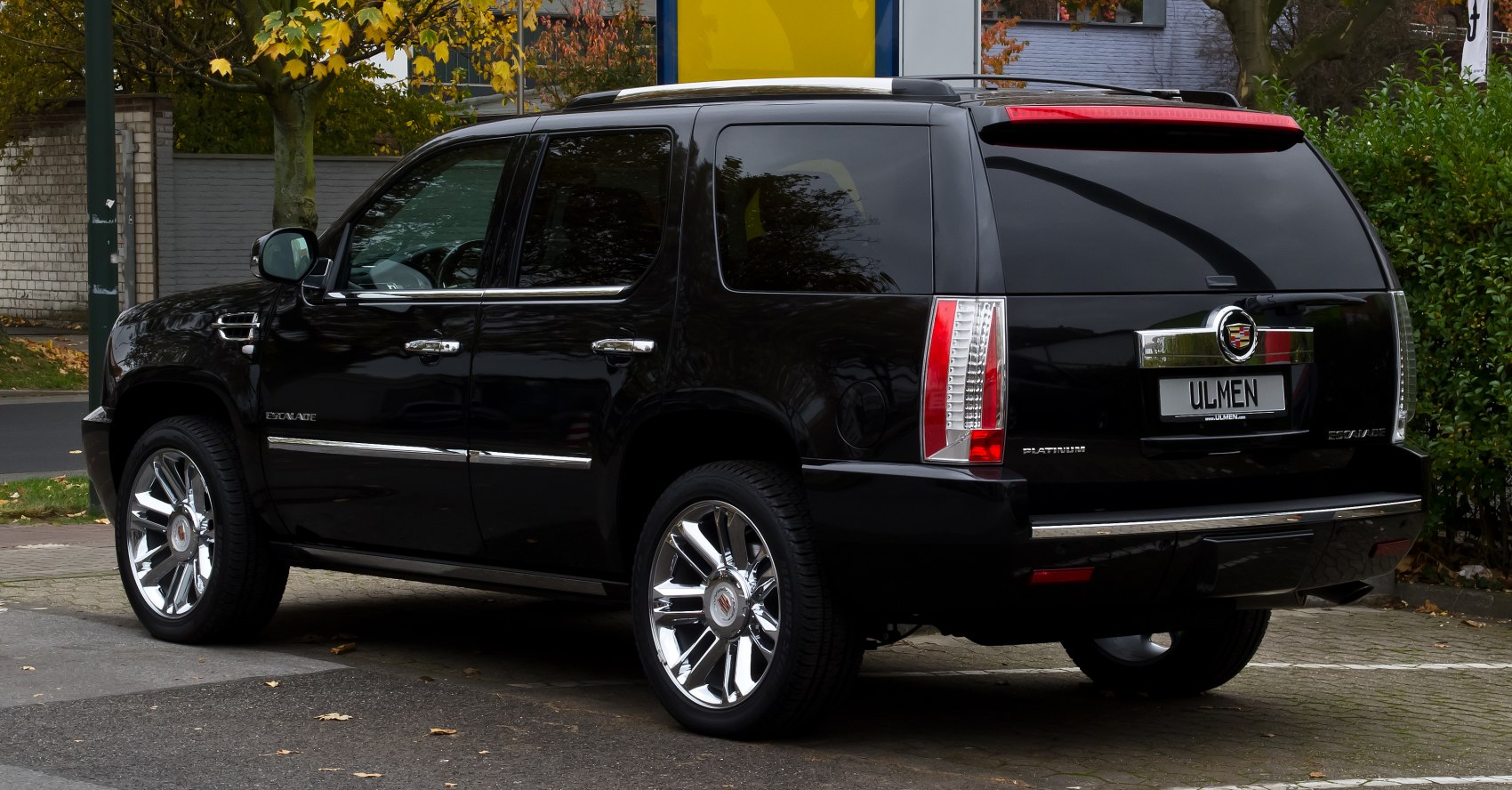 Black luxury SUV with chrome wheels and tinted windows rear view