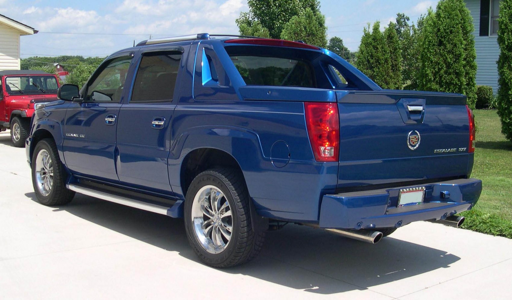 Luxury pickup with extended cab, pickup bed, and dual exhausts.