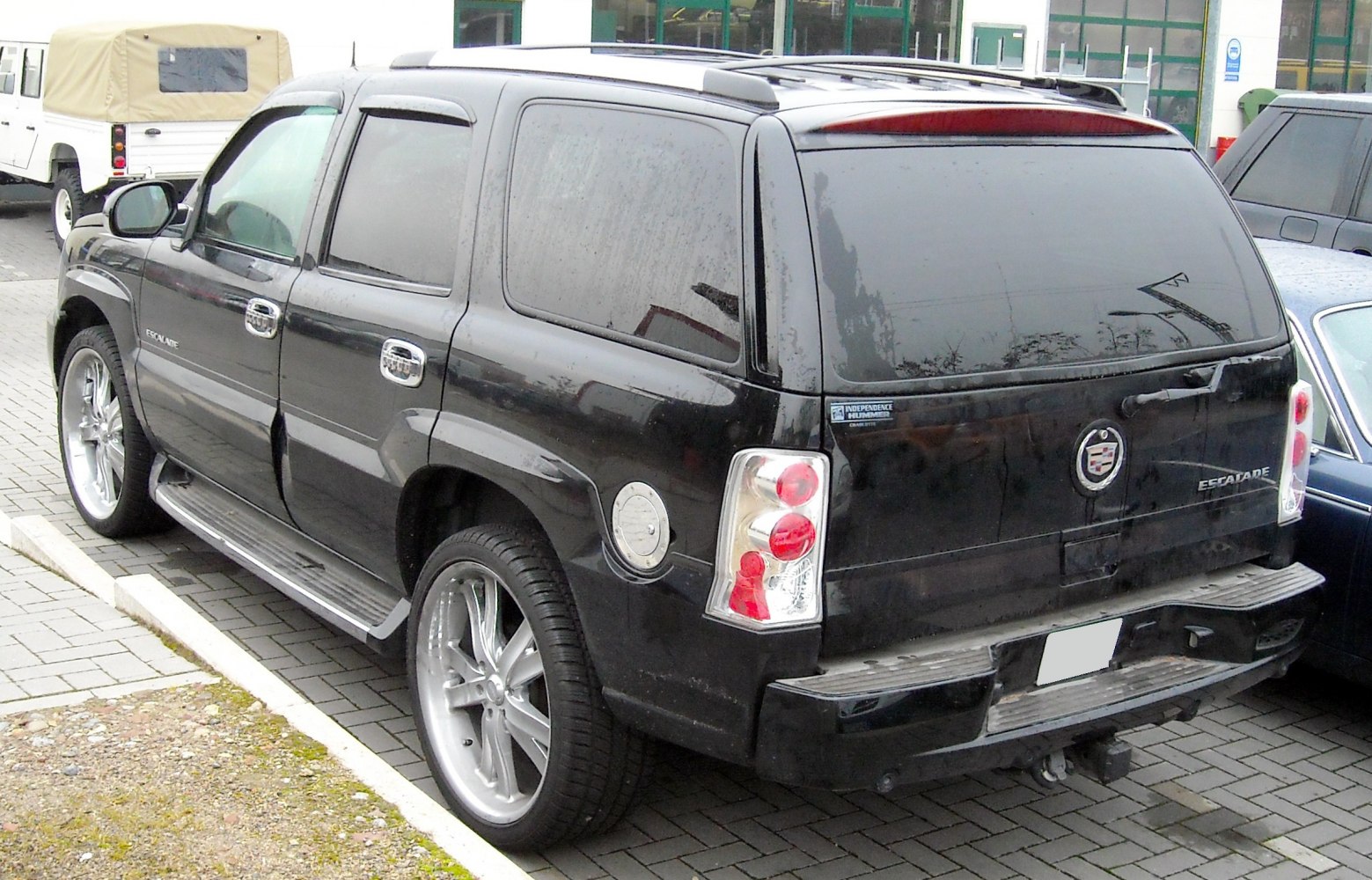 Rear side view with large alloy wheels, tinted windows, and rear lighting