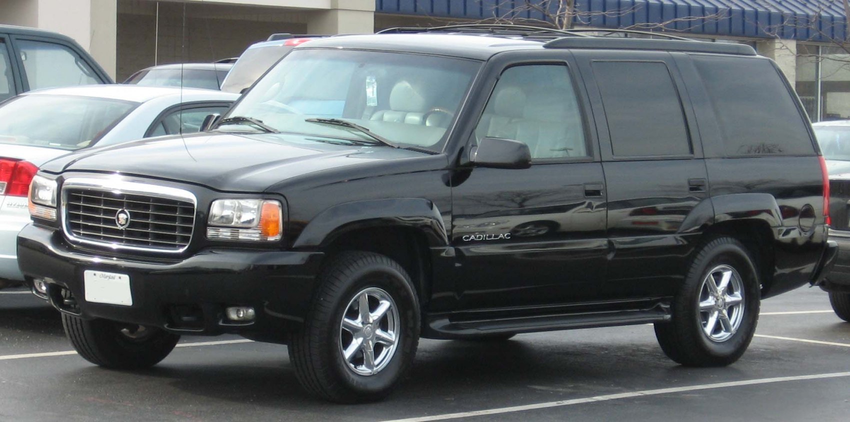 Front side view of a black SUV with chrome wheels and tinted windows