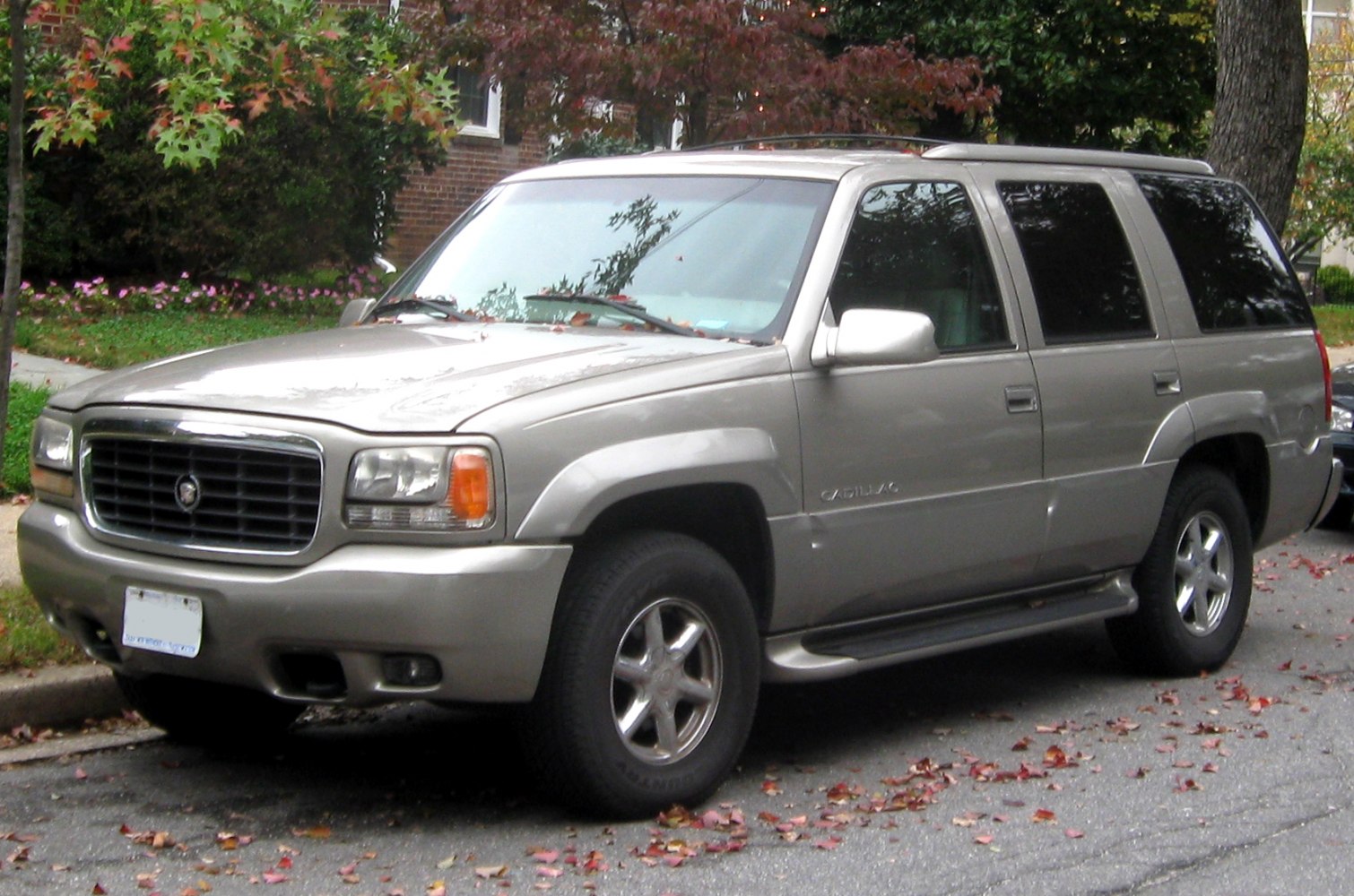 Front side view of silver SUV with roof rails and running boards