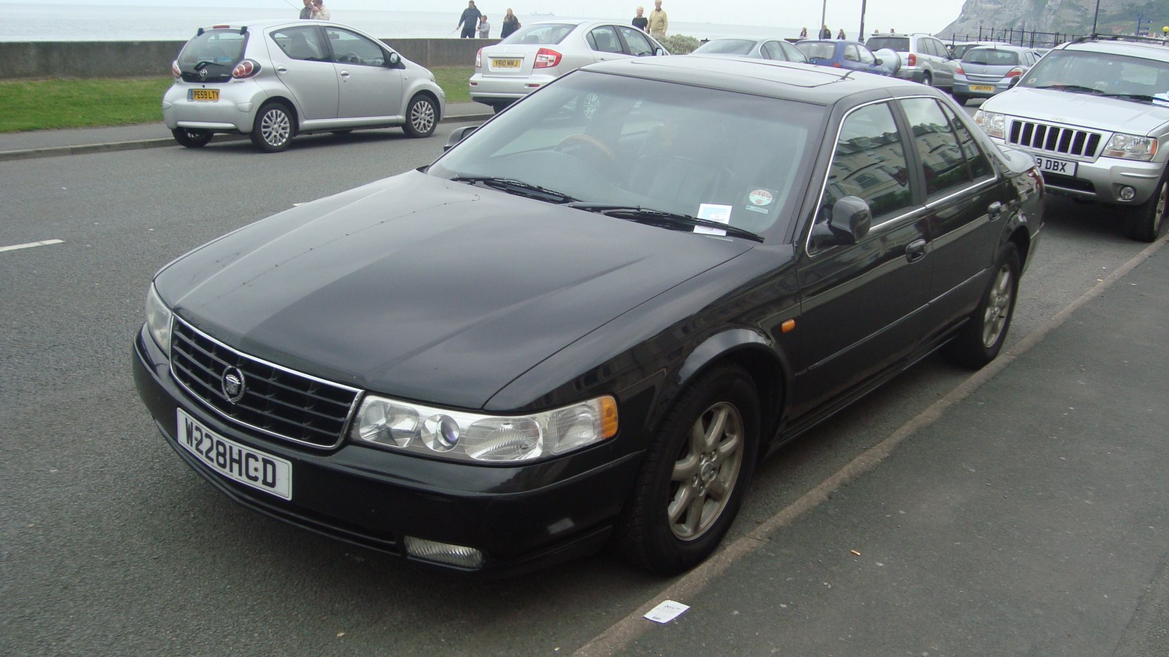 Black sedan front side view with grille and alloy wheels