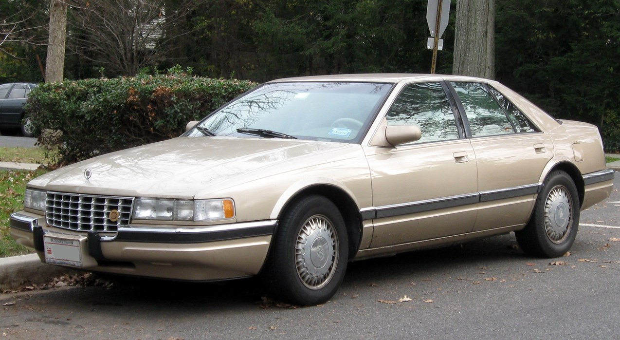 Classic luxury sedan with chrome grille and alloy wheels parked on street