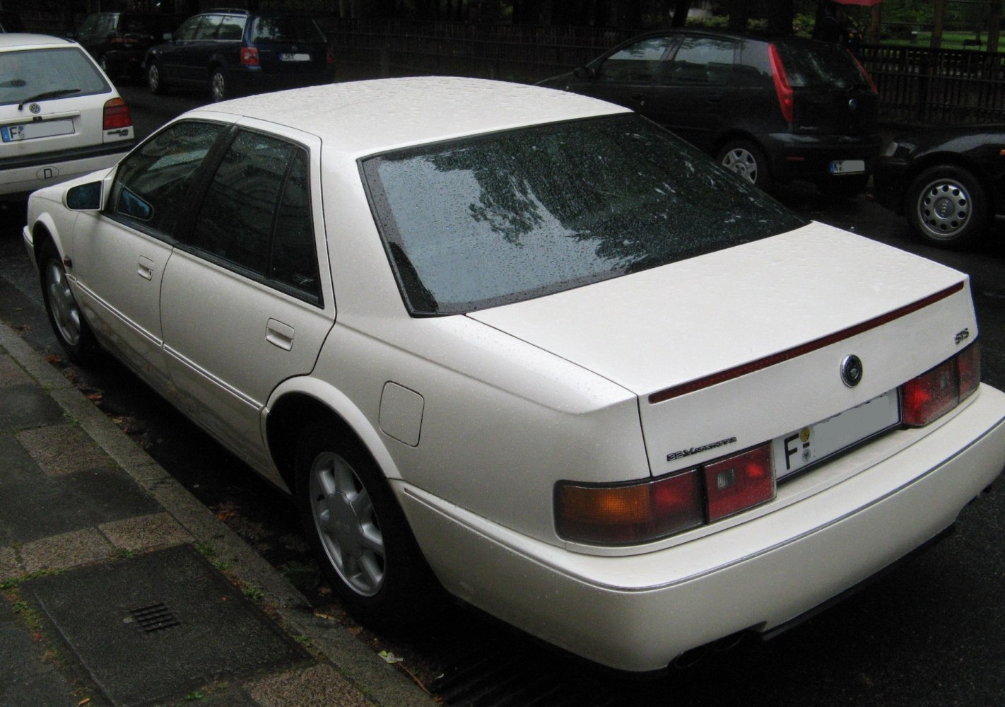Rear side view of a sedan with distinctive tail lights and rear window.