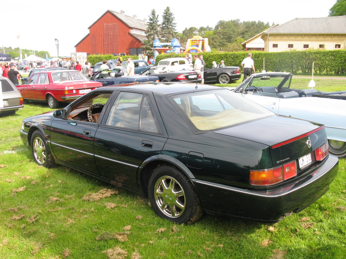 Luxury sedan with rear light bar and chrome wheels.