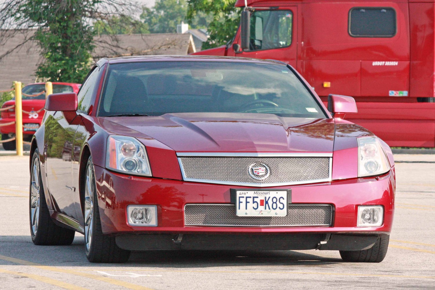 Red sports coupe front with mesh grille and distinctive headlights
