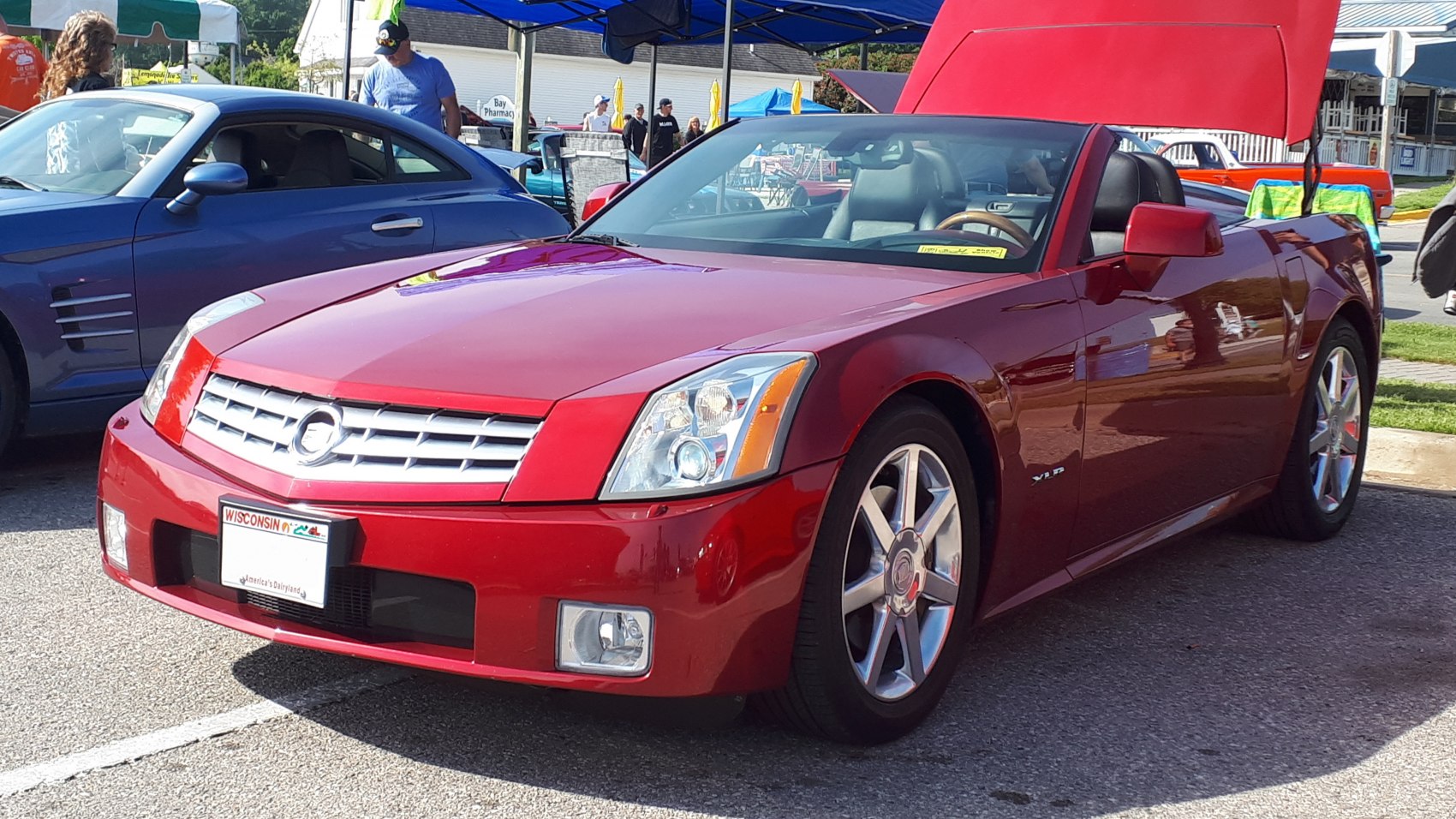 Red convertible front-side view with grille and alloy wheels