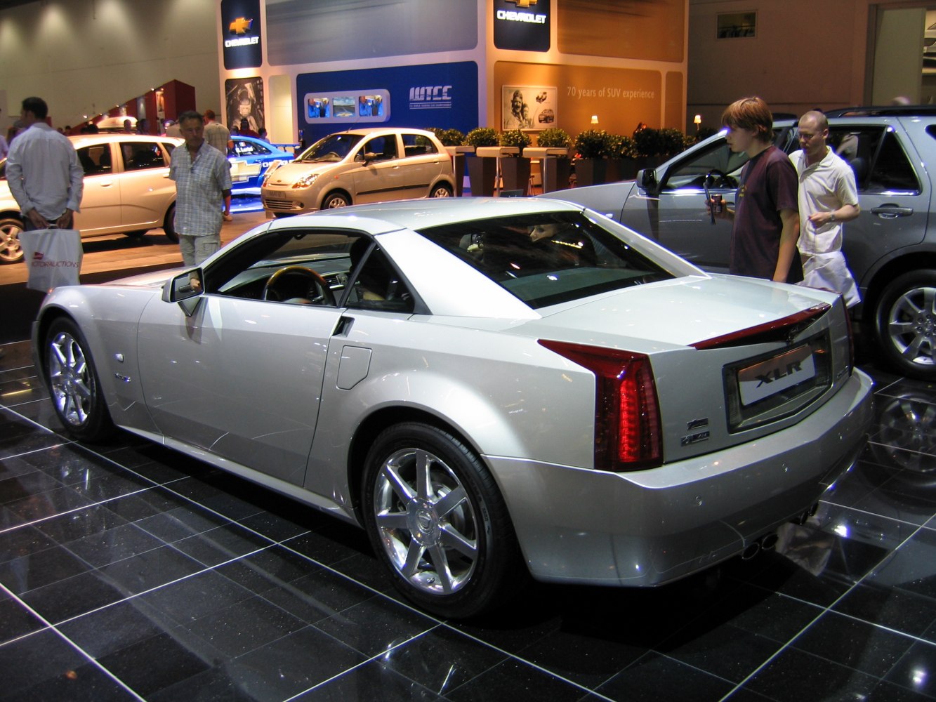 Sporty coupe rear and side view with chrome wheels and sleek shape