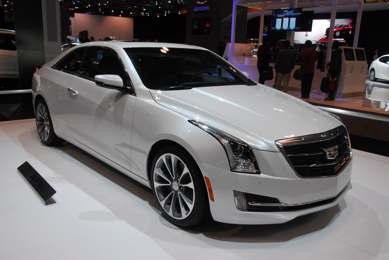 Front and side view of a white coupe with distinctive headlight design