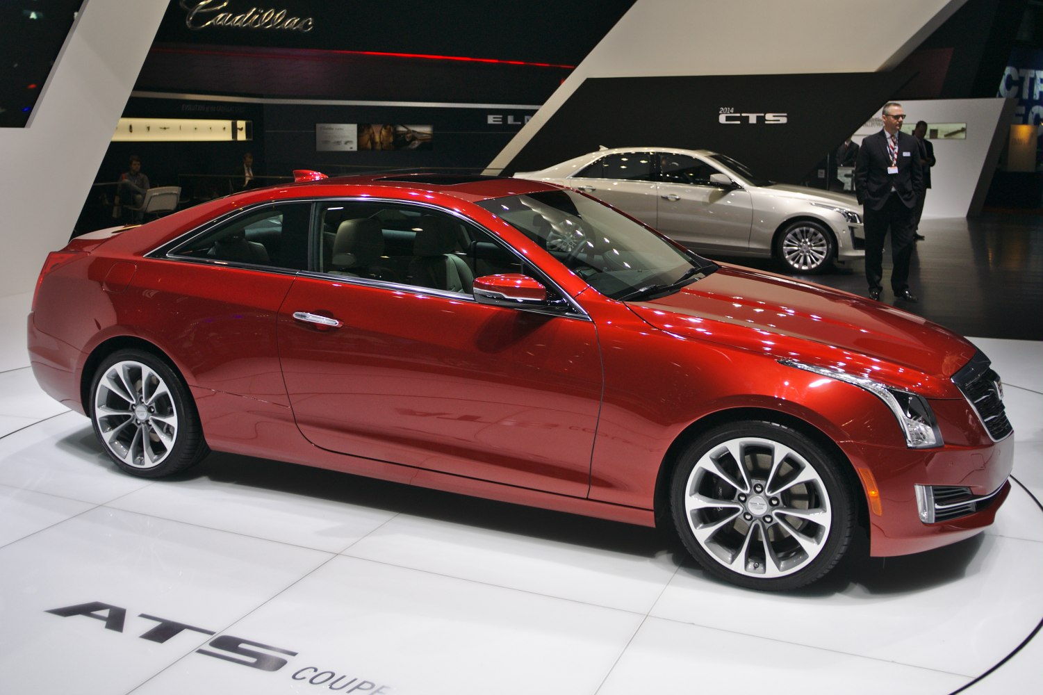 Sleek red two-door coupe with distinctive alloy wheels in side profile.
