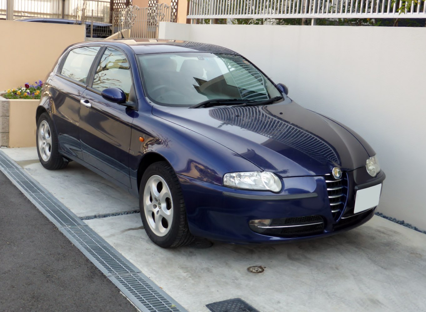 Front-side view of blue hatchback with rounded headlights and alloy wheels