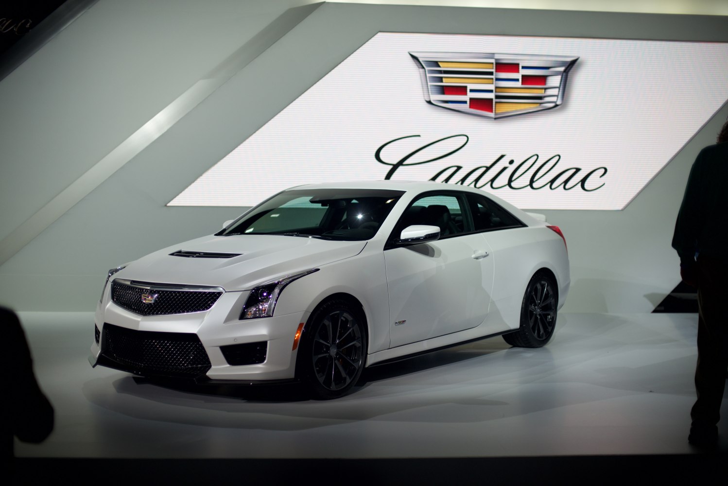 White luxury coupe shown from front and side angles with aerodynamic shape and sharp lines