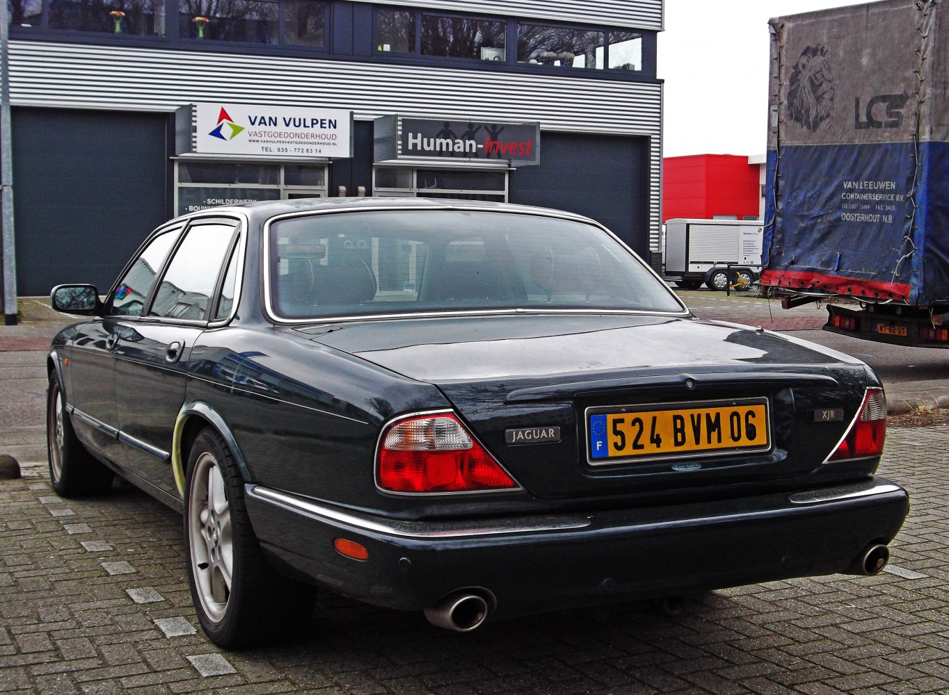 Rear view with distinct tail lights and dual exhaust of a sleek sedan
