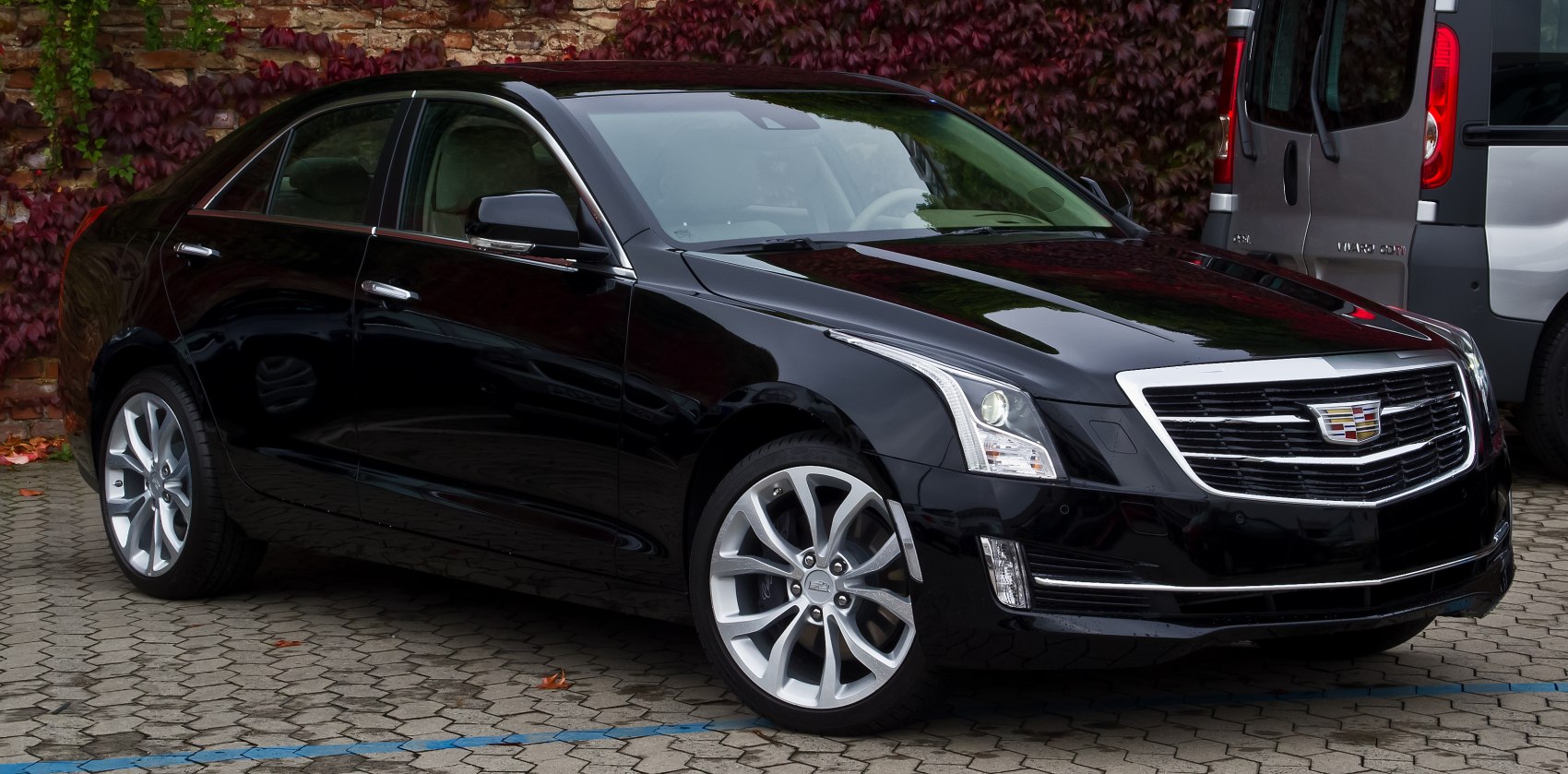 Sleek black midsize luxury sedan with a bold grille and alloy wheels