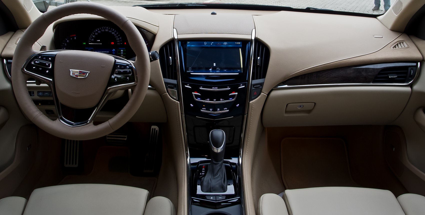 Beige leather interior with touchscreen center console and steering wheel controls