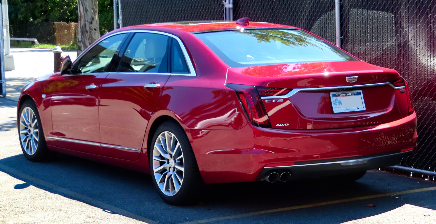 Red luxury sedan with distinct taillights and dual exhausts.
