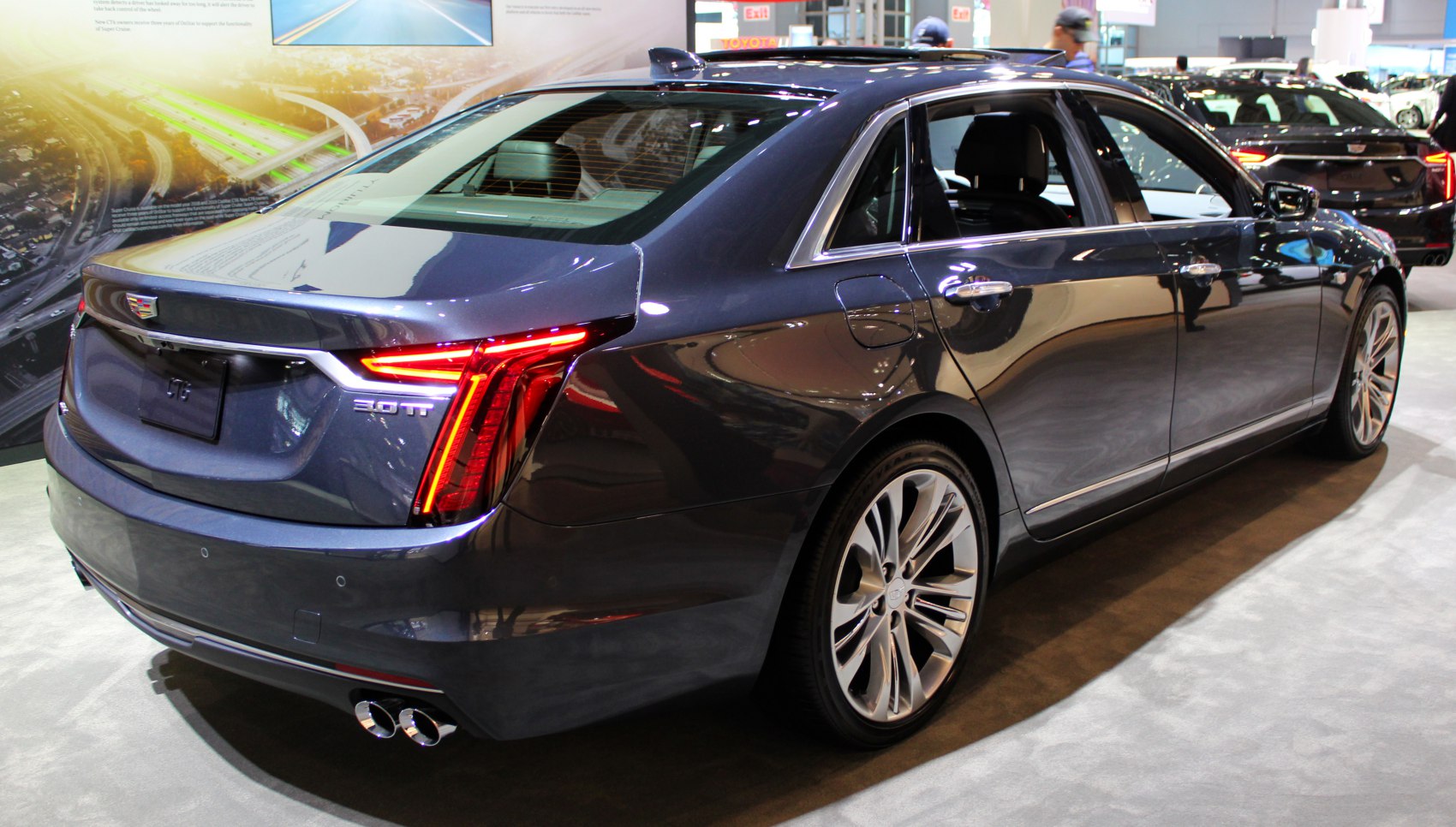 Luxury sedan rear with distinctive tail lights and dual exhausts