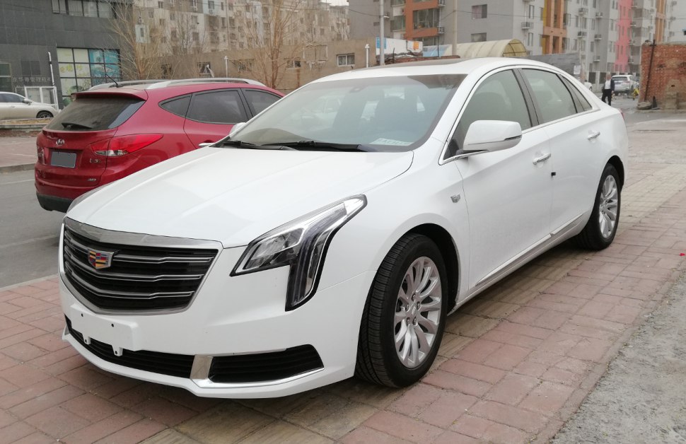 Sleek luxury sedan with vertical LED headlights and multi-slat grille