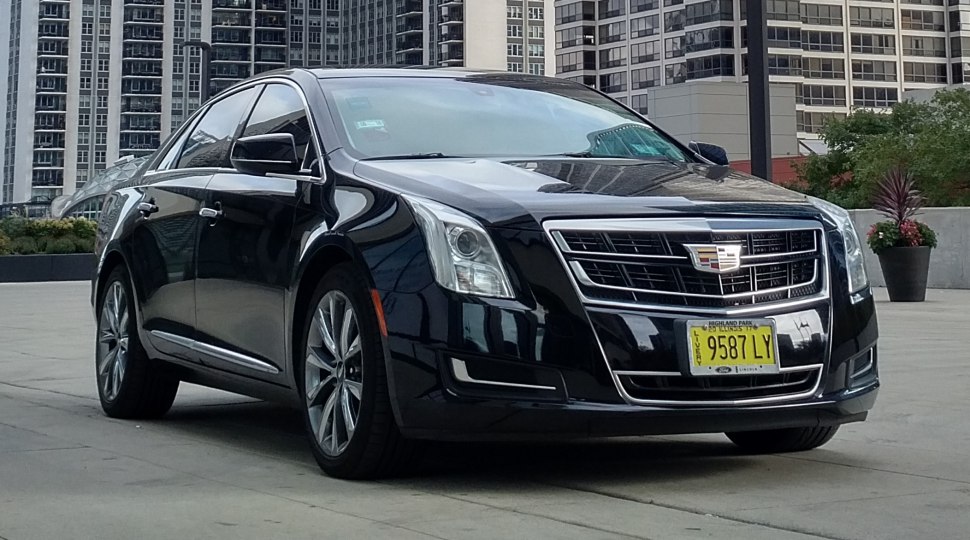 Front 3/4 view of black luxury sedan with signature grille and alloy wheels