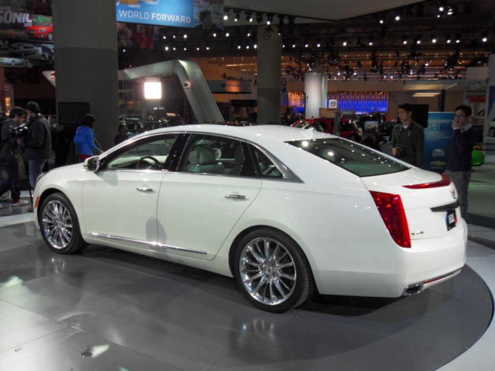 Luxury sedan rear and side view with chrome multi-spoke wheels