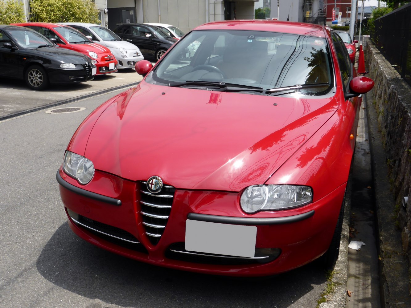 Red 5-door hatchback front with Alfa Romeo grille and headlights