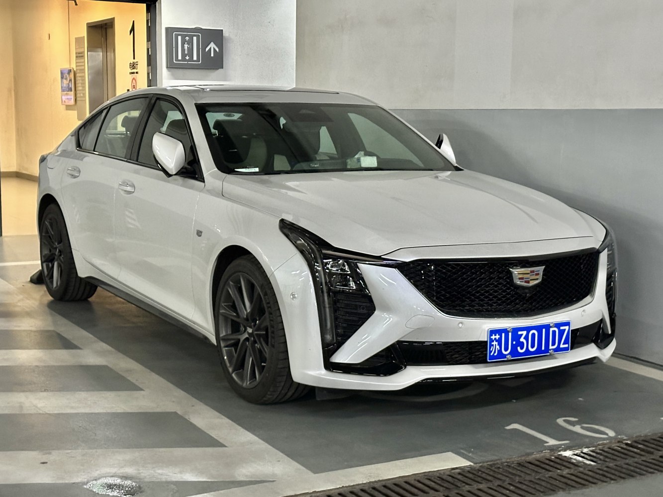 White sedan with black alloy wheels and aggressive front grille