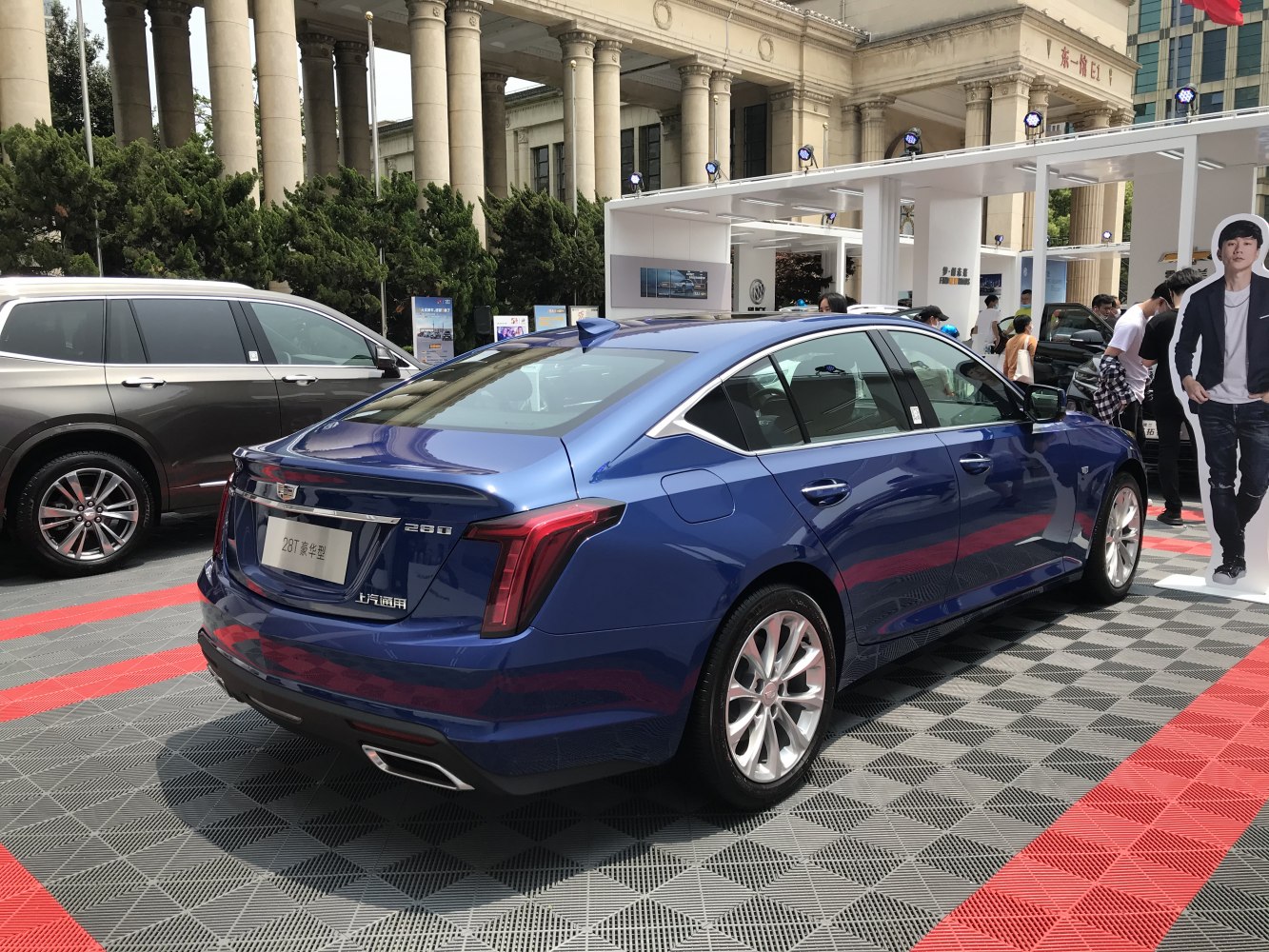 Rear and side profile of blue sedan with distinctive tail lights and alloy wheels