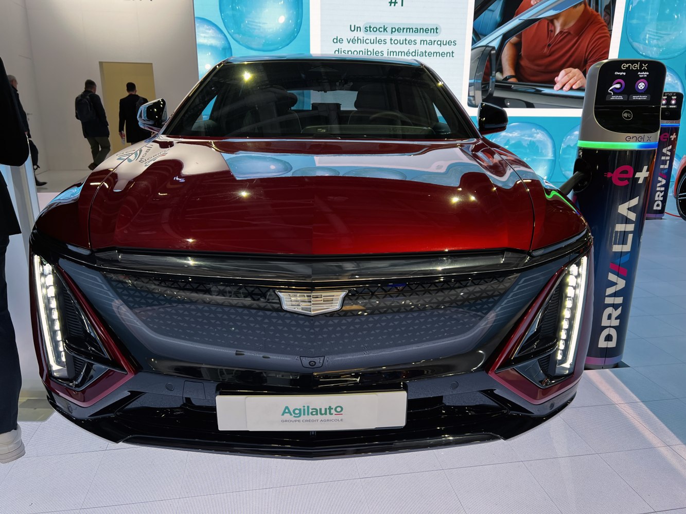 Front view of electric vehicle with LED headlights and charging station
