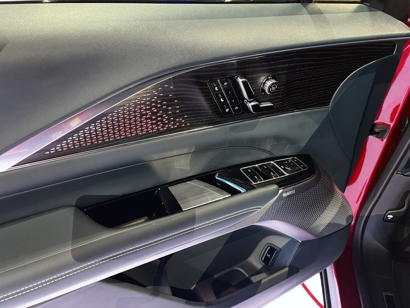 Luxury car door panel with seat controls and AKG speaker detail