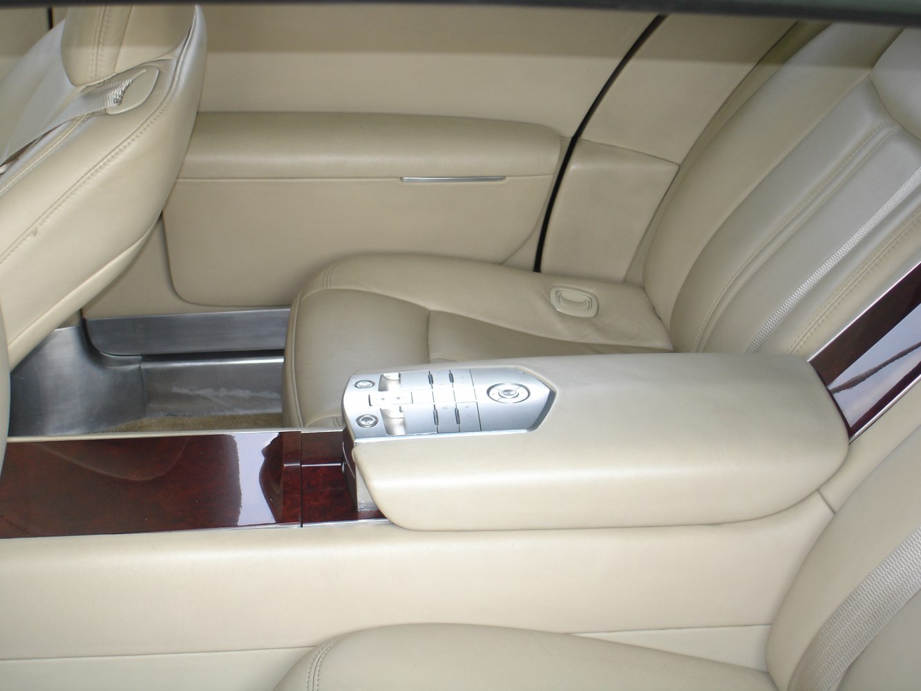 Rear seat with beige leather upholstery and central armrest with integrated controls