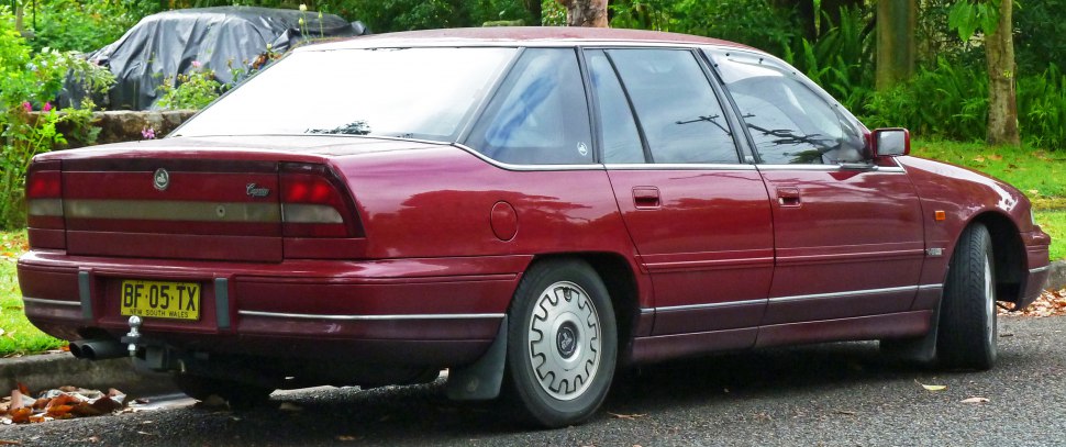 Rear and side view of a maroon luxury sedan with distinct classic design and sedan features