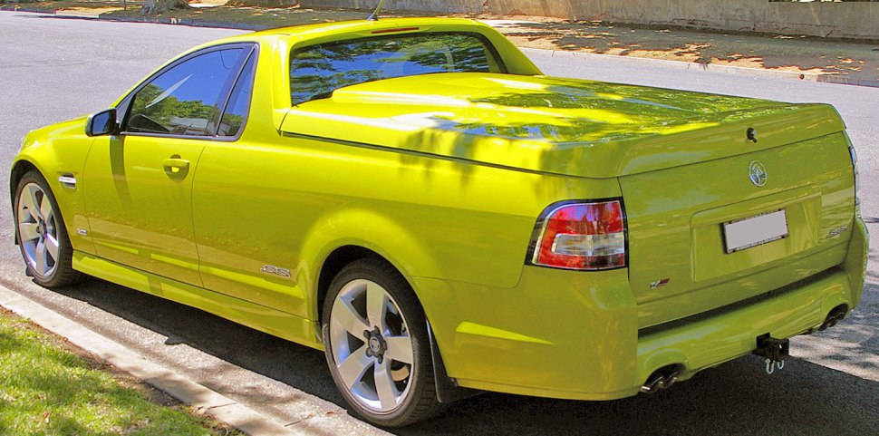 Bright yellow utility vehicle with hard tonneau cover and alloy wheels