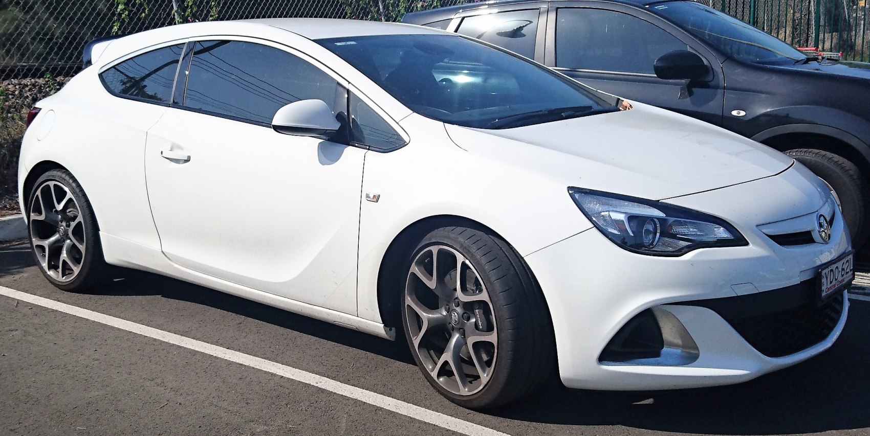 White 3-door hatchback with sleek headlights and multi-spoke alloy wheels