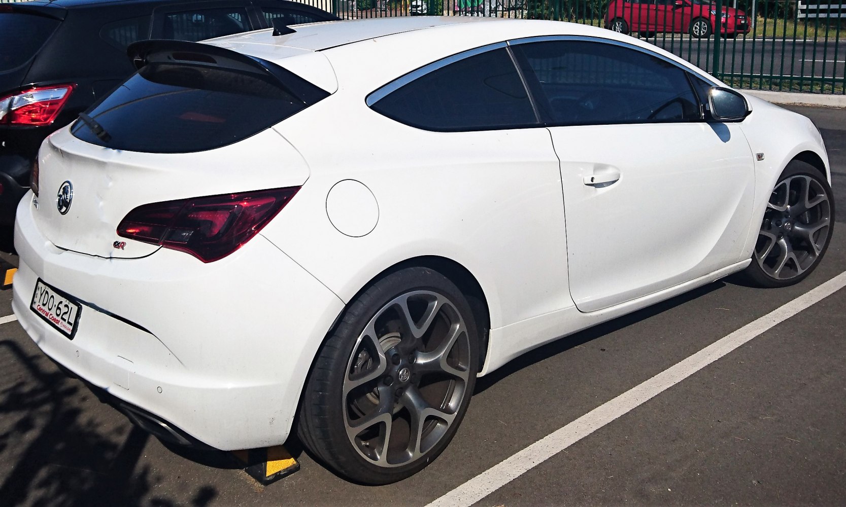 White sports hatchback with large alloy wheels and rear spoiler
