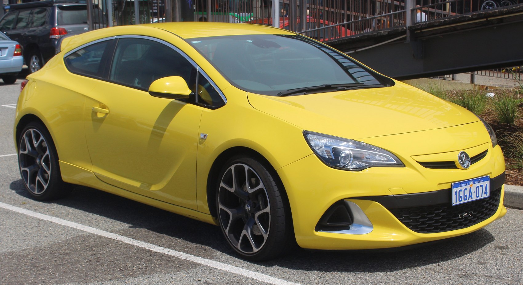 Yellow 3-door hatchback with sporty alloy wheels and aerodynamic front.