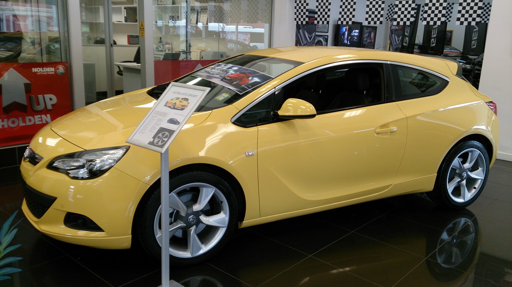 Yellow hatchback with sporty alloy wheels and sleek 3-door design