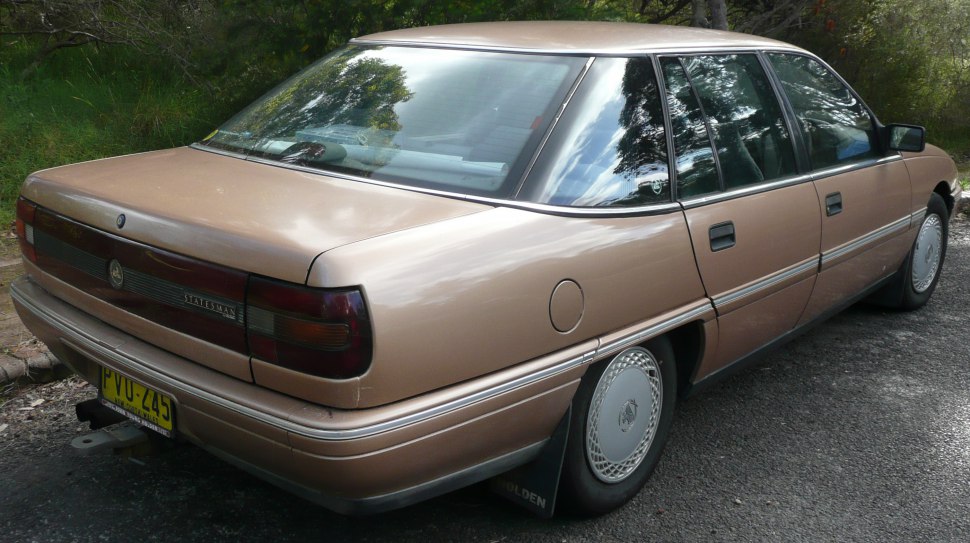 Classic sedan rear side with distinct rear lights and wheel covers