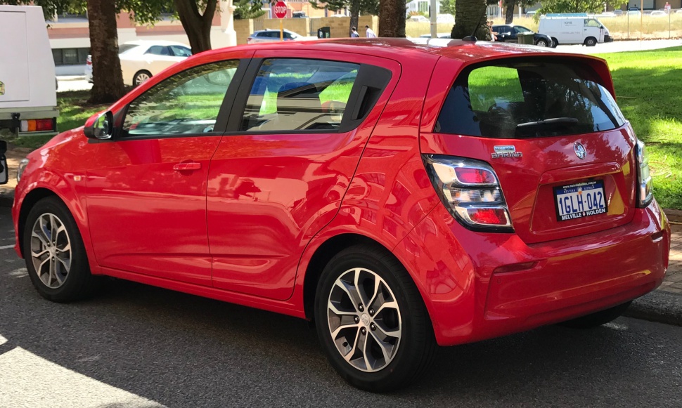 Red hatchback rear side view with tail lights and alloy wheels