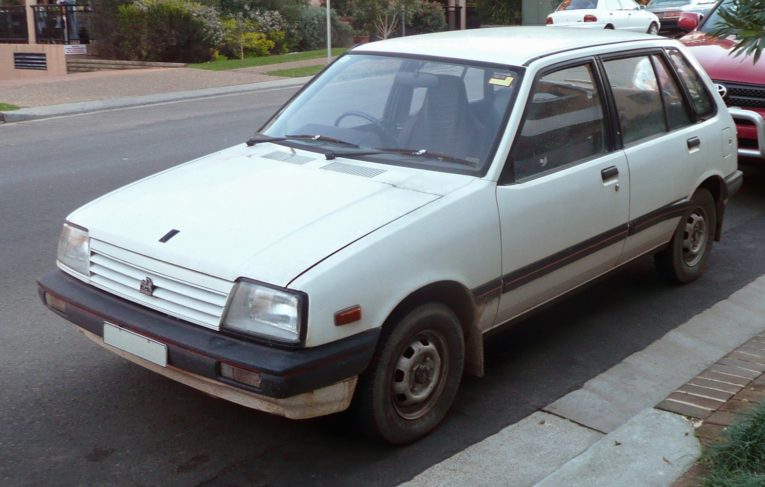 Compact hatchback with rectangular headlights and black bumpers.
