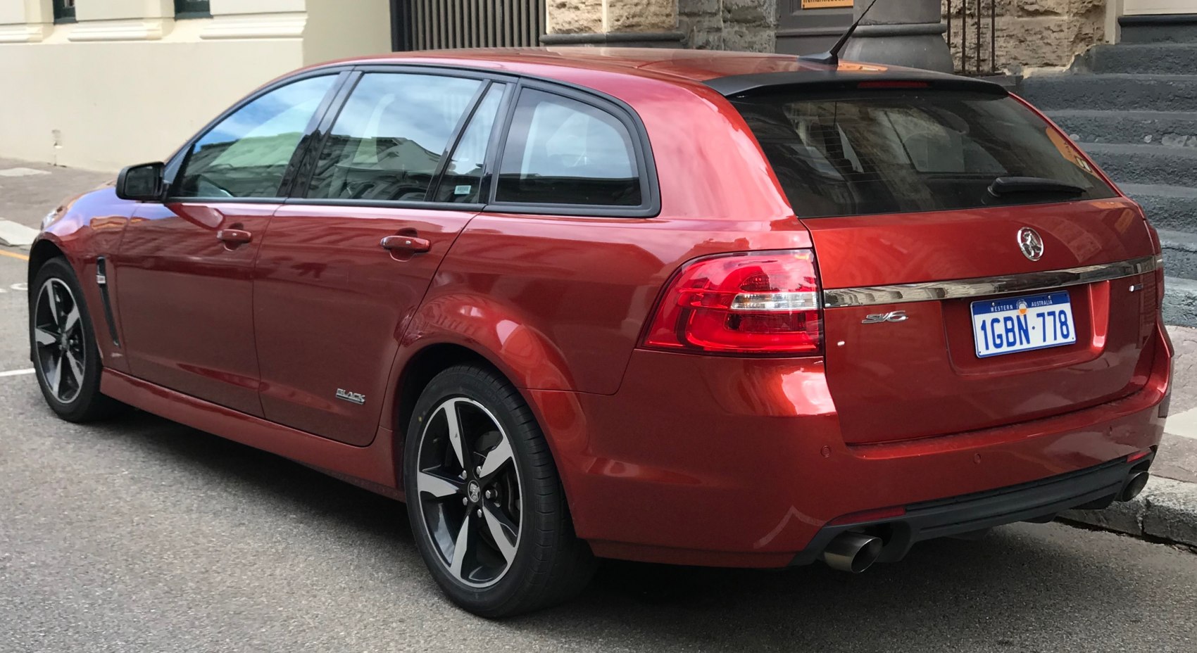 Red station wagon rear side view with distinctive tail lights and alloy wheels